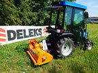 Compact tractor with DELEKS APE flail mower cutting grass on a slope