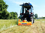 Compact tractor with DELEKS APE flail mower cutting tall grass and brush