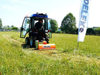 Compact tractor mowing a field with a DELEKS APE flail mower