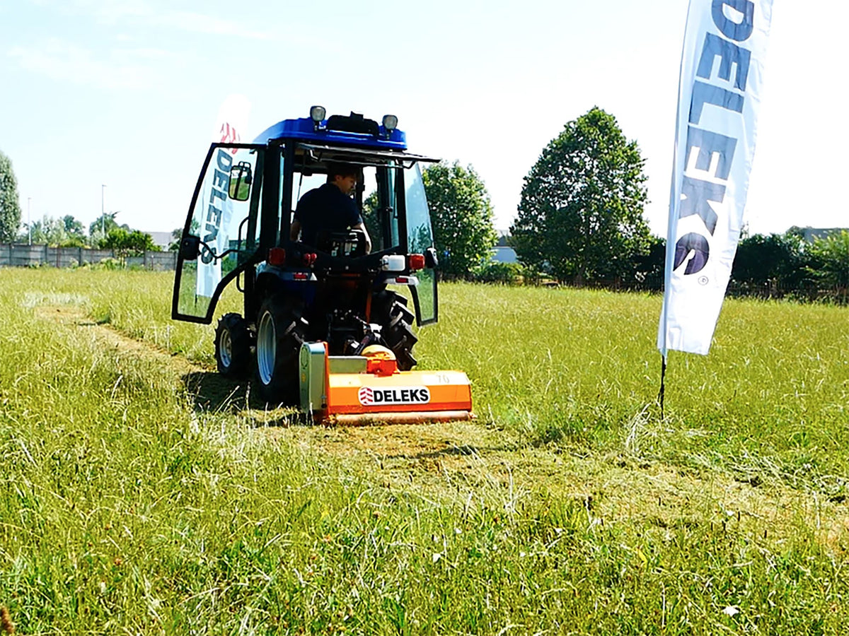 Compact tractor mowing a field with a DELEKS APE flail mower