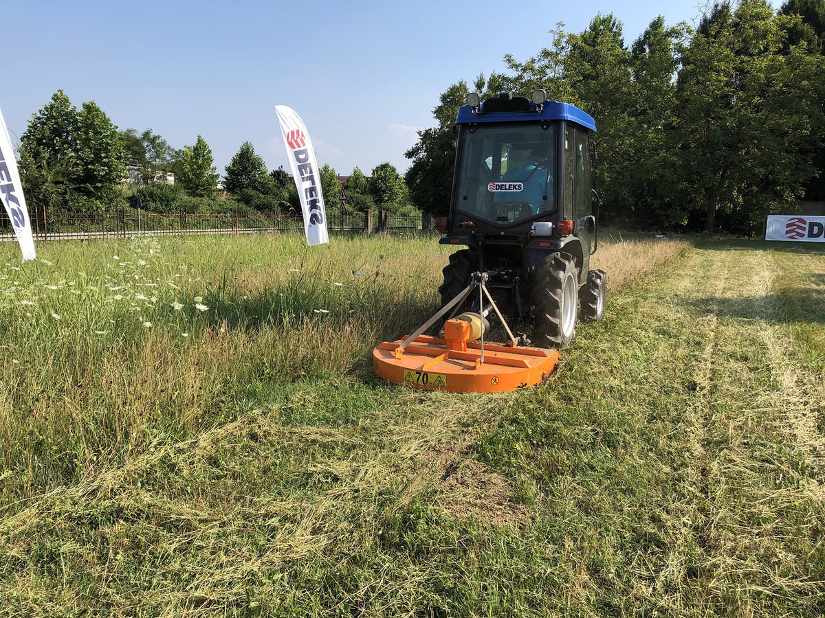 Compact tractor mowing a field with the DELEKS BUGGY rotary cutter
