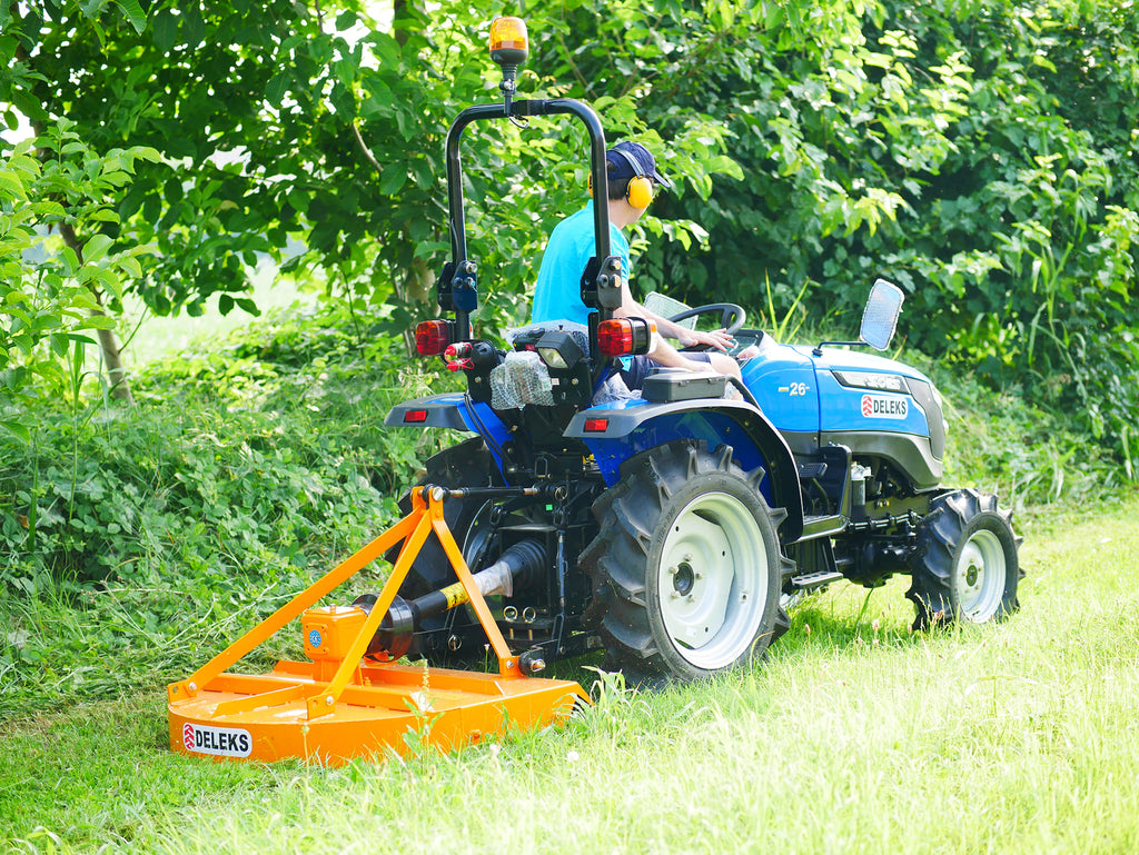 Compact tractor mowing under trees with the DELEKS BUGGY rotary cutter