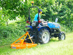 Compact tractor mowing under trees with the DELEKS BUGGY rotary cutter