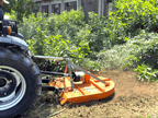 Close-up of the DELEKS BUGGY C chain rotary cutter behind a tractor
