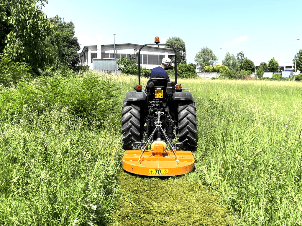 Compact tractor cutting tall grass with the DELEKS BUGGY