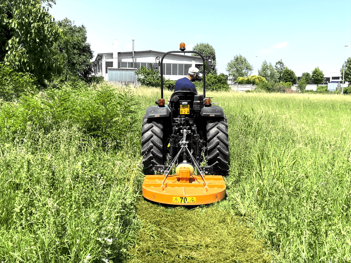 Compact tractor cutting tall grass with the DELEKS BUGGY