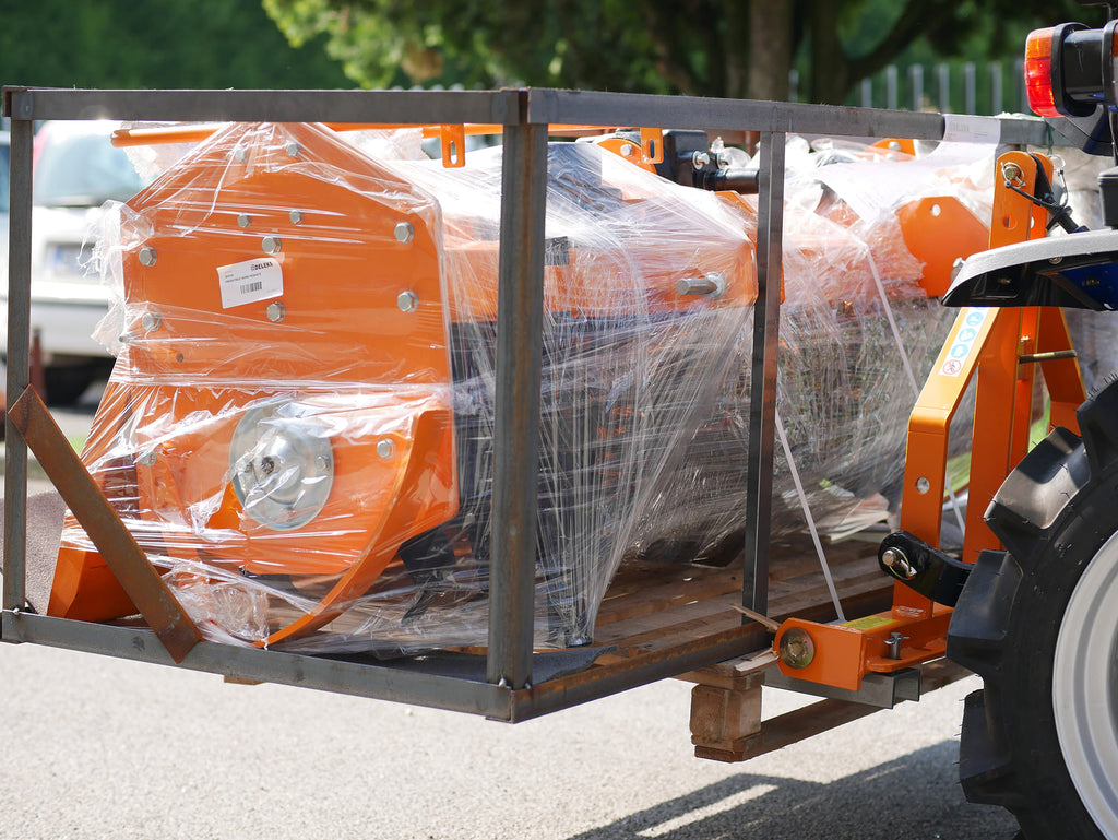 Compact tractor carrying a crate with DELEKS D-300 forks, side view