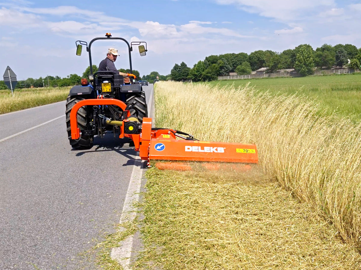 Tractor mowing a roadside verge with the DELEKS GIRAFFA offset flail mower
