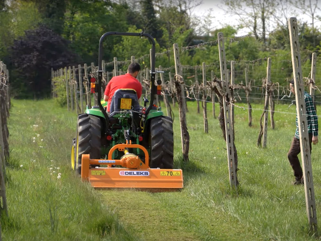 Compact tractor mowing a vineyard with the DELEKS LINCE flail mower